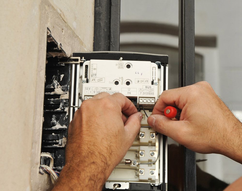 A Man is Working on an Electrical Box With a Red Screwdriver — Gealy's Air-Conditioning, Refrigeration & Electrical in Noosaville, QLD