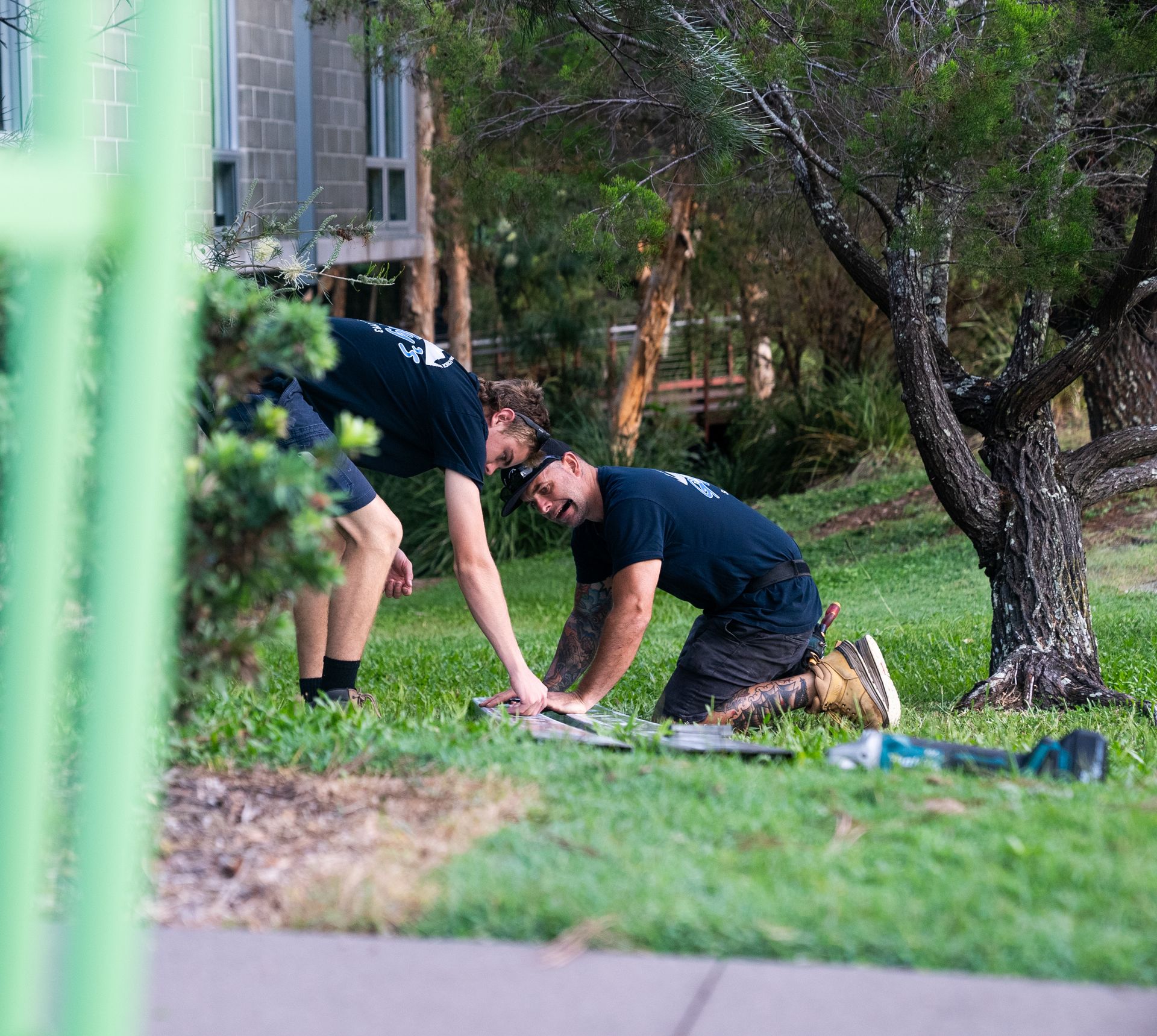 2 people working outside on the grass— Gealy's Air-Conditioning, Refrigeration & Electrical in Noosaville, QLD