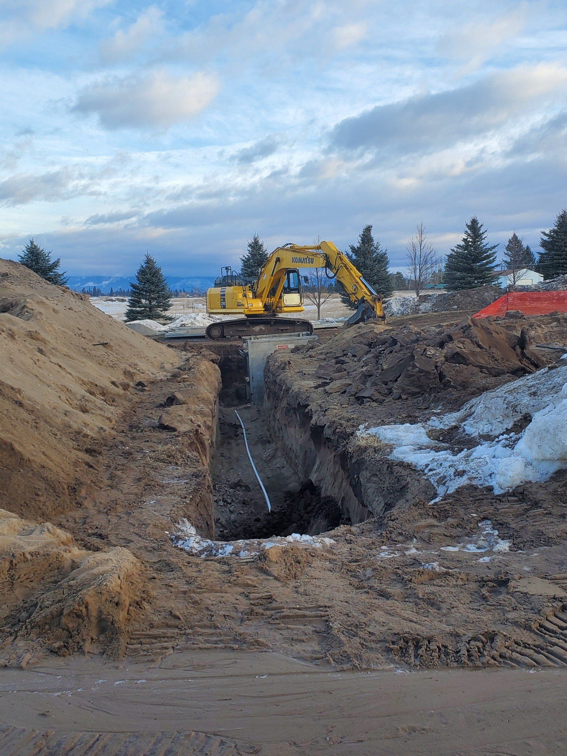 A yellow excavator is digging a hole in the ground.