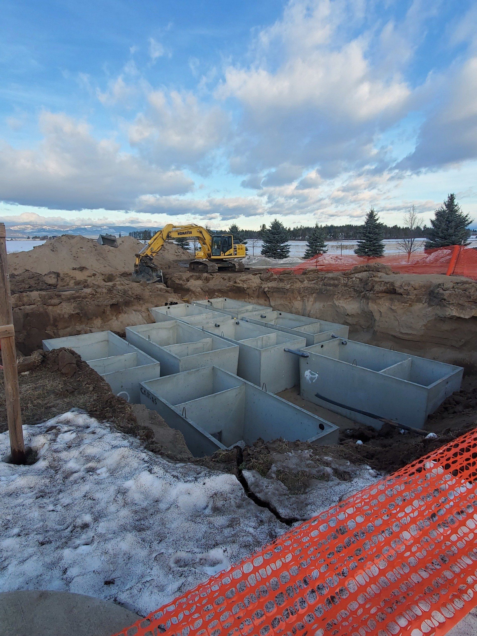 A construction site with a yellow excavator in the background.