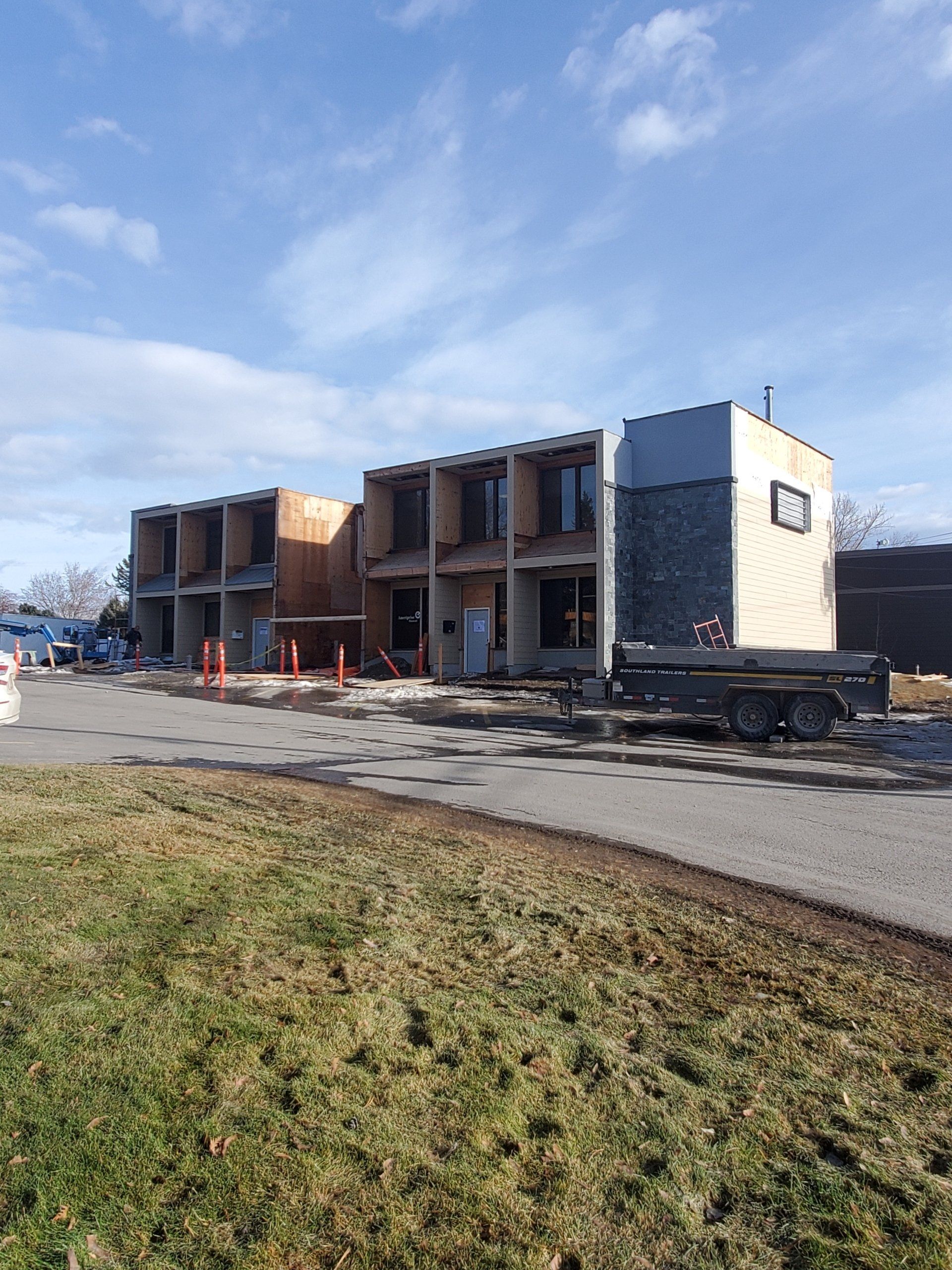 A large building is being built in the middle of a grassy field.