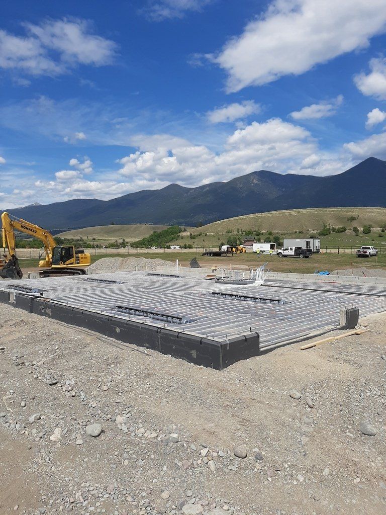 A construction site with a bulldozer and mountains in the background.