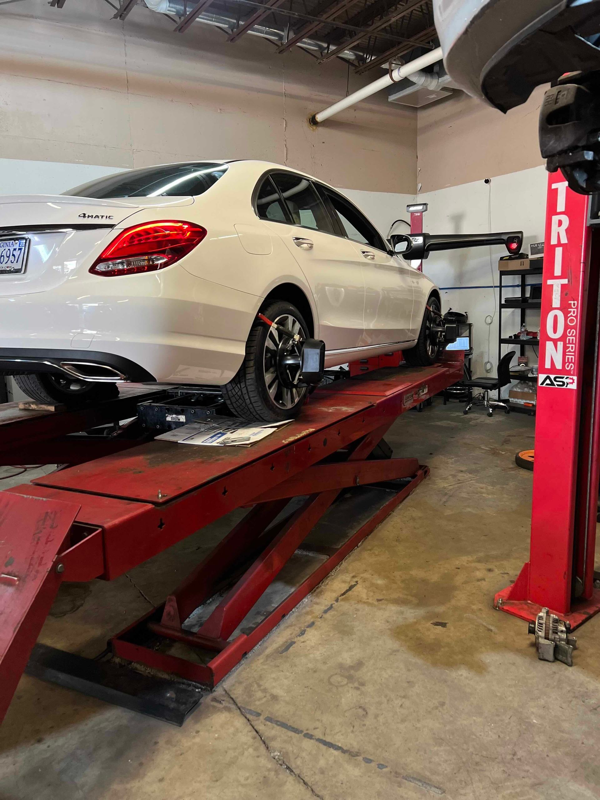 White Mercedes On Hydraulic Lift For Inspection | Premier Auto LLC
