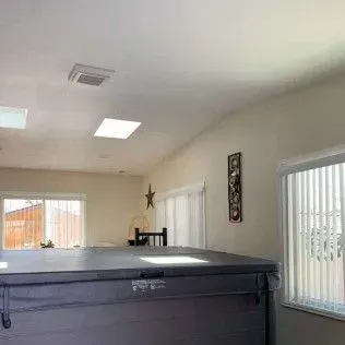 Hot tub inside room with skylights and windows.