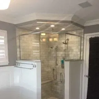Bathroom with a large, glass-enclosed shower, neutral tiles, and white walls.