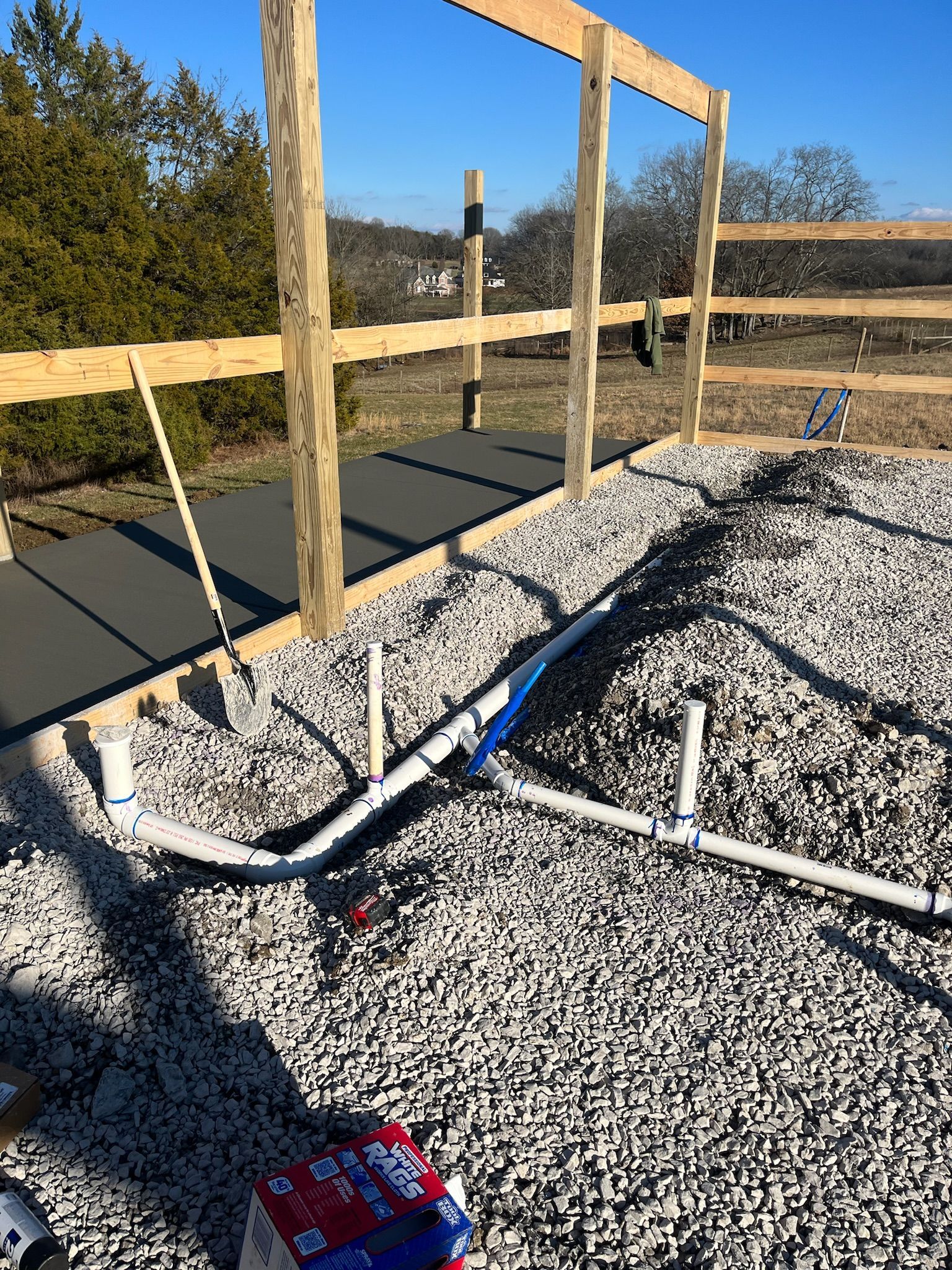 A hose is laying on the ground next to a fence.