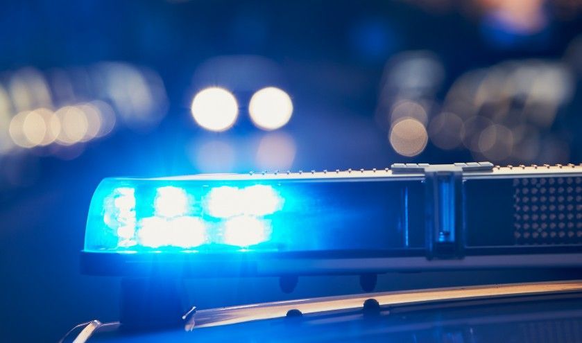 A close up of a blue police light on top of a police car.