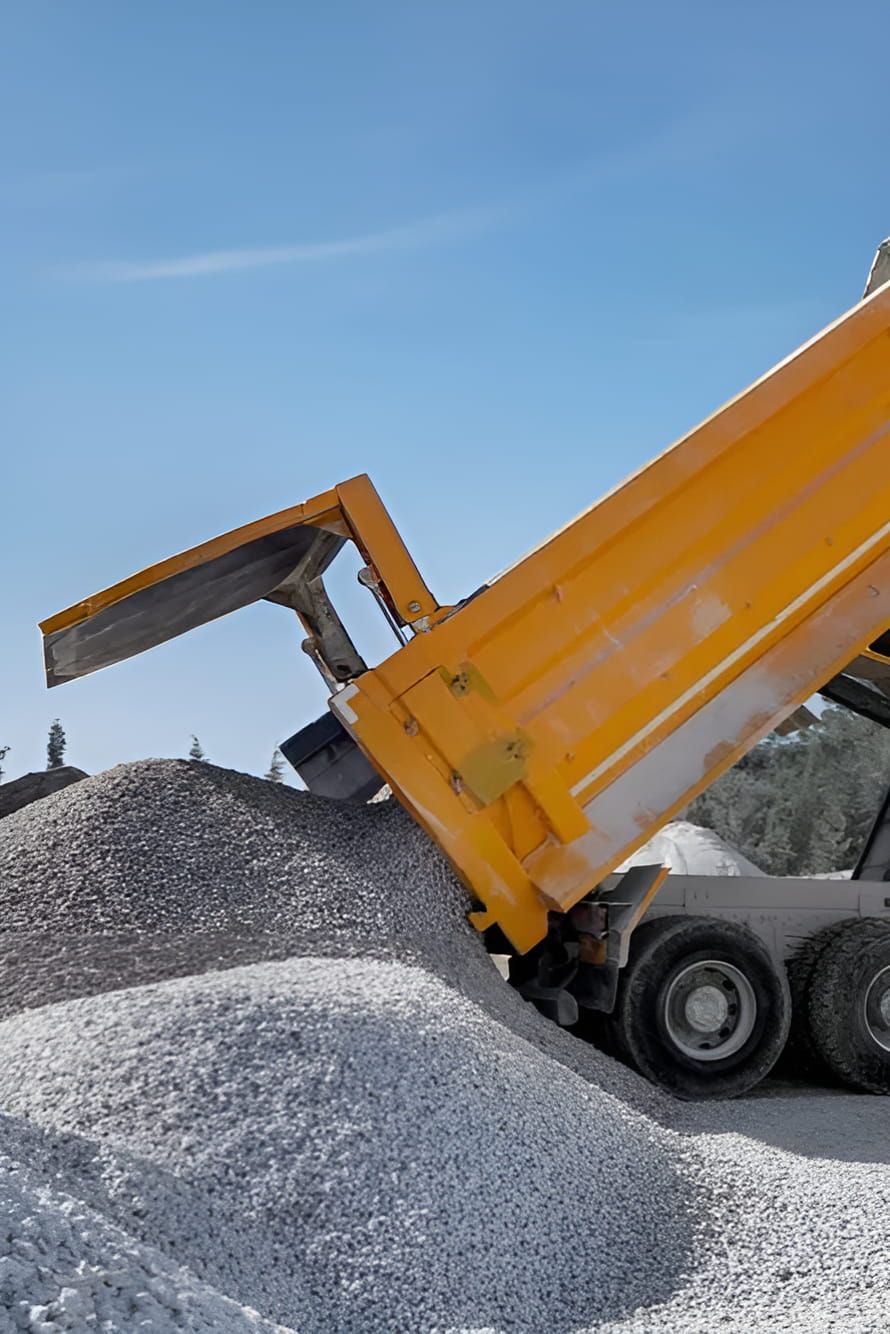 A Yellow Dump Truck is Being Loaded With Gravel — A & B Mullins Excavations Pty Ltd in Bungadoo, QLD
