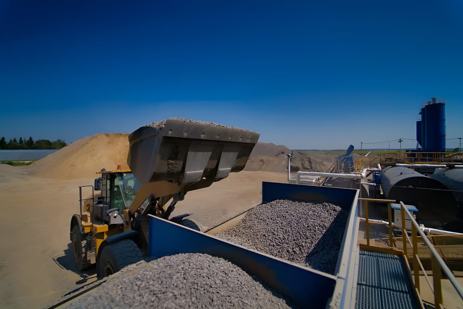 A Bulldozer is Loading Gravel Into a Truck —  A & B Mullins Excavations Pty Ltd in Bungadoo, QLD