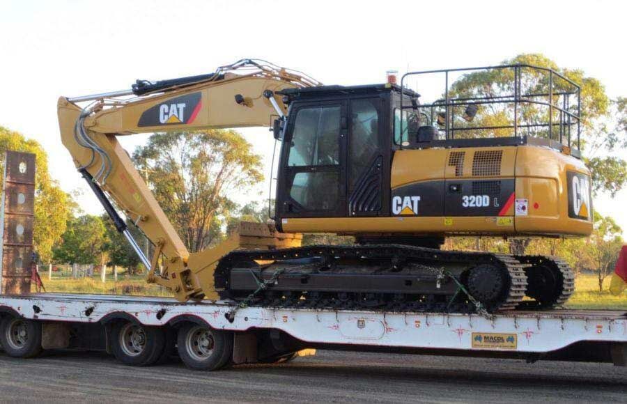 A Cat Excavator is Sitting on Top of a Flatbed Trailer — A & B Mullins Excavations Pty Ltd in Bundaberg, QLD