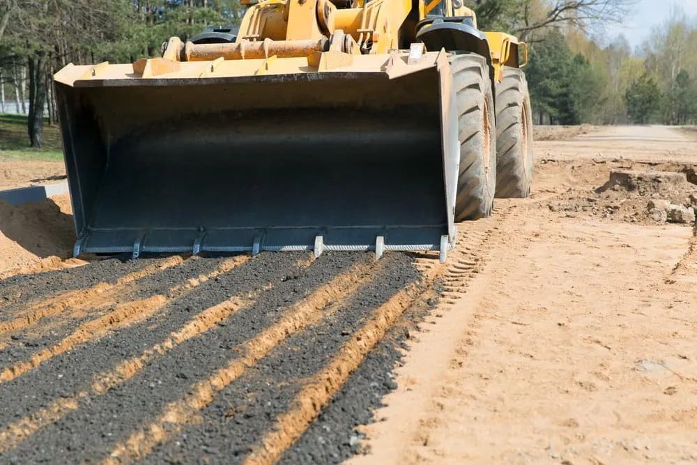 A Bulldozer is Moving Dirt on a Road — A & B Mullins Excavations Pty Ltd in Bundaberg, QLD