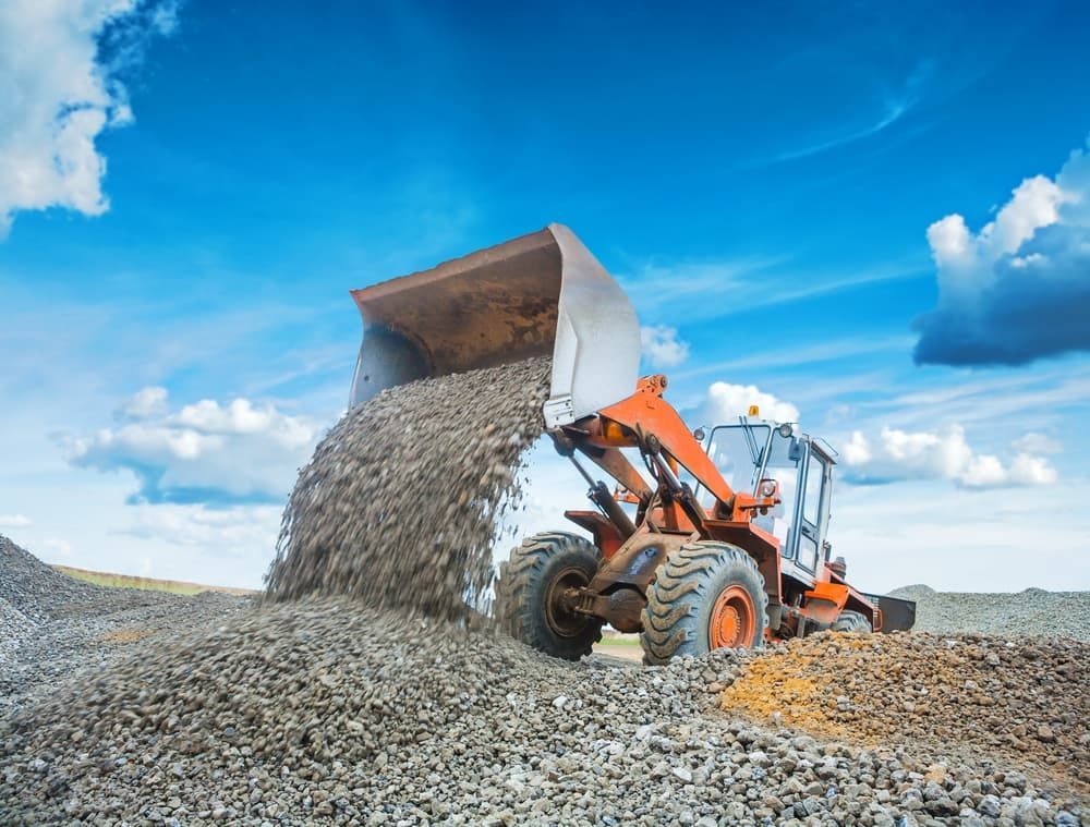 A Bulldozer is Pouring Gravel Into a Pile at a Construction Site — A & B Mullins Excavations Pty Ltd in Bungadoo, QLD