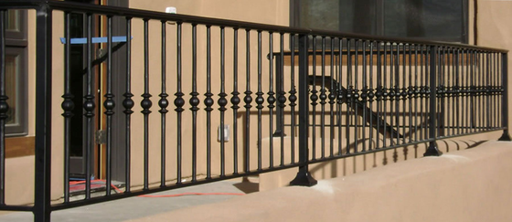 Black metal balcony railing with decorative balusters on a building's exterior.