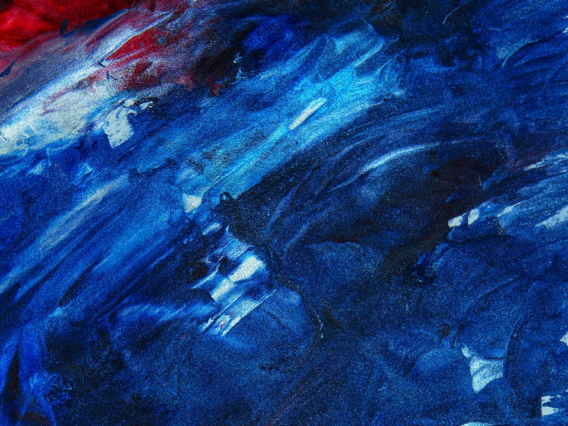 Abstract painting with blue, red, and white brushstrokes, creating a textured surface.