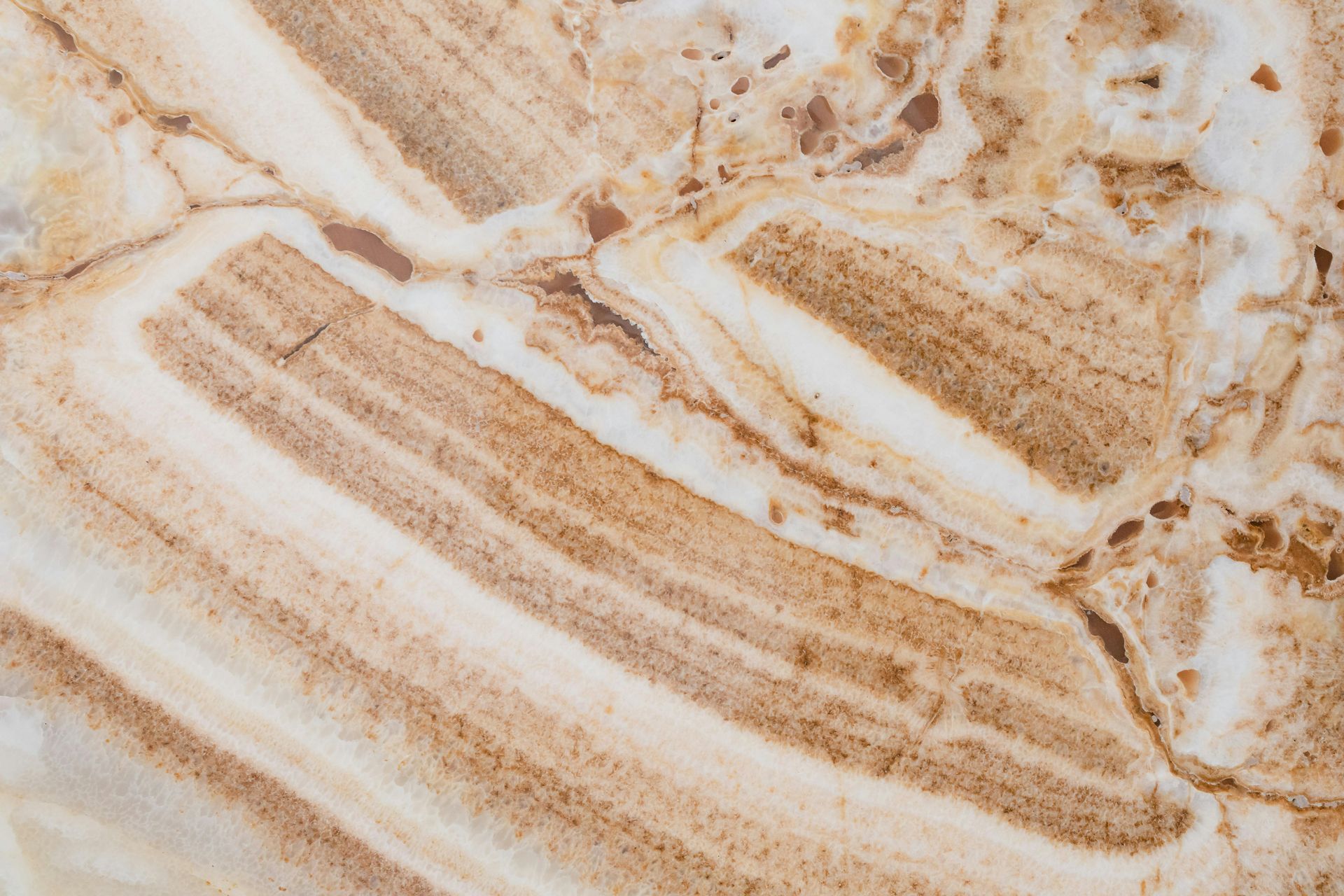 Tan and white marble with layered bands and veining.
