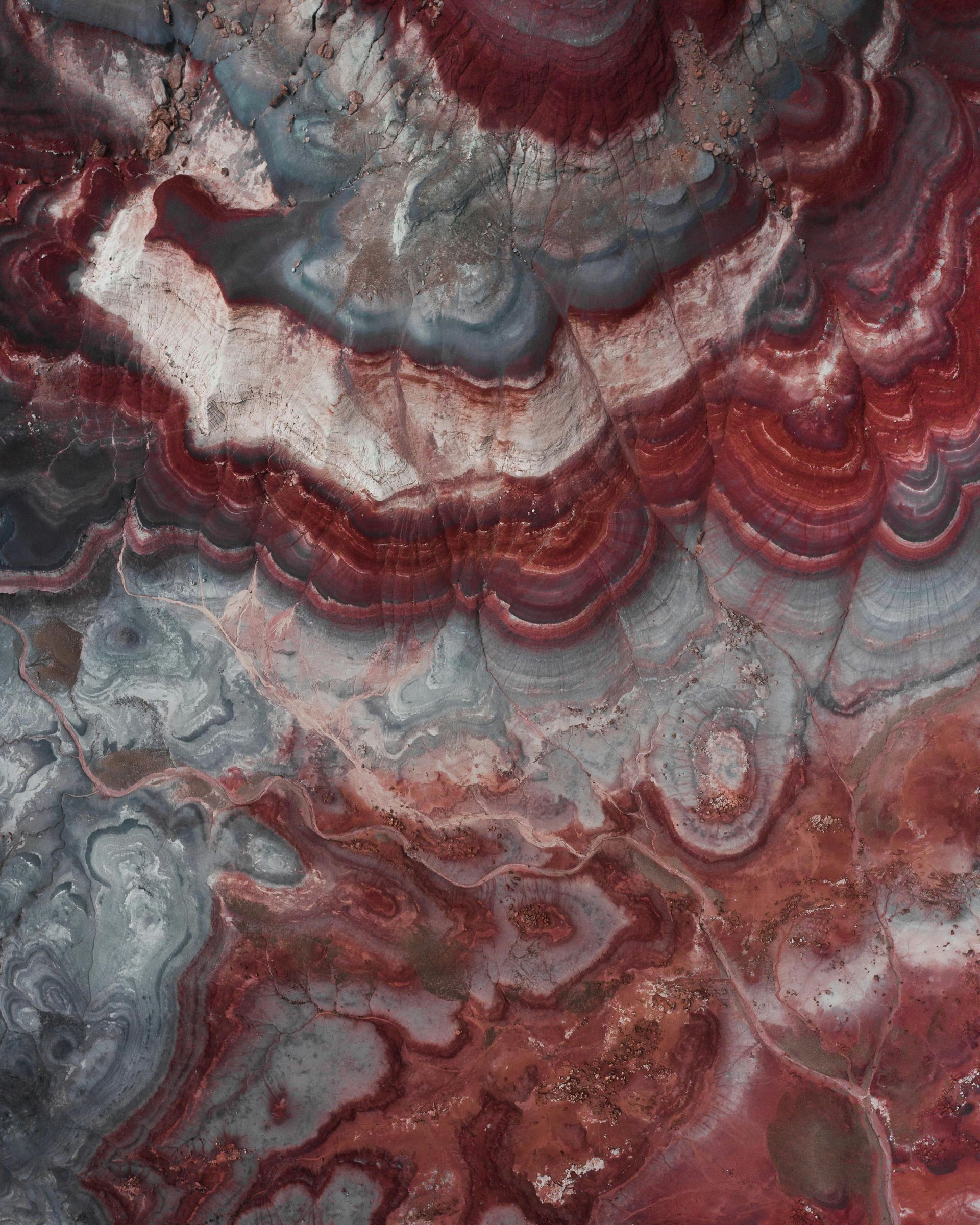 Swirling red, gray, and white banded stone texture.