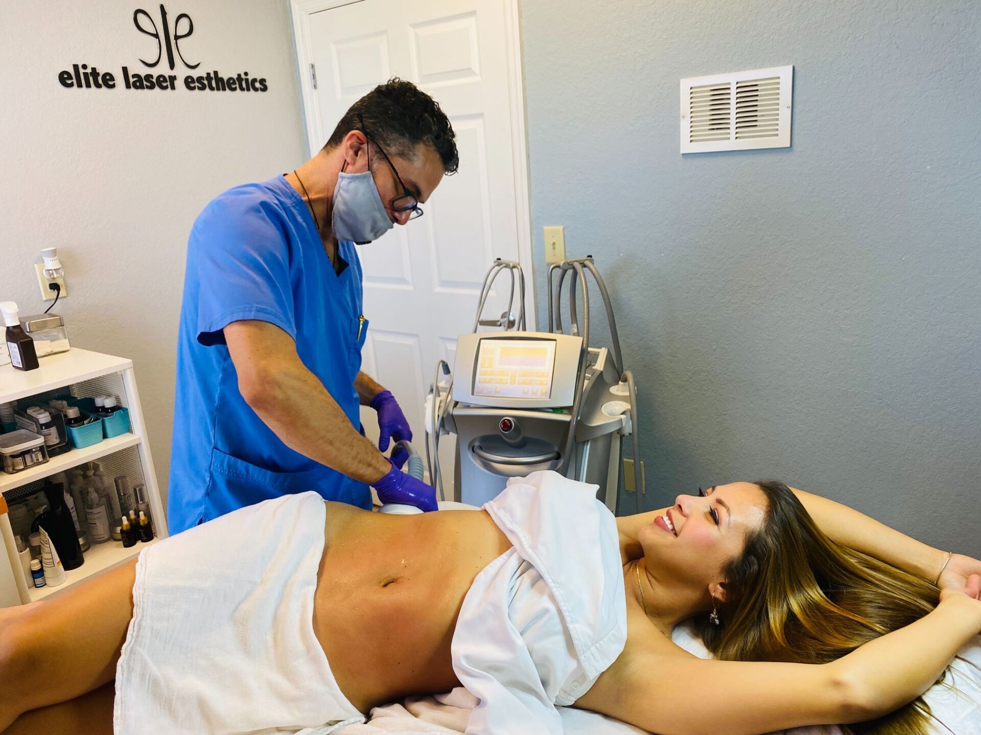 A woman wrapped in a towel is getting a treatment from a doctor