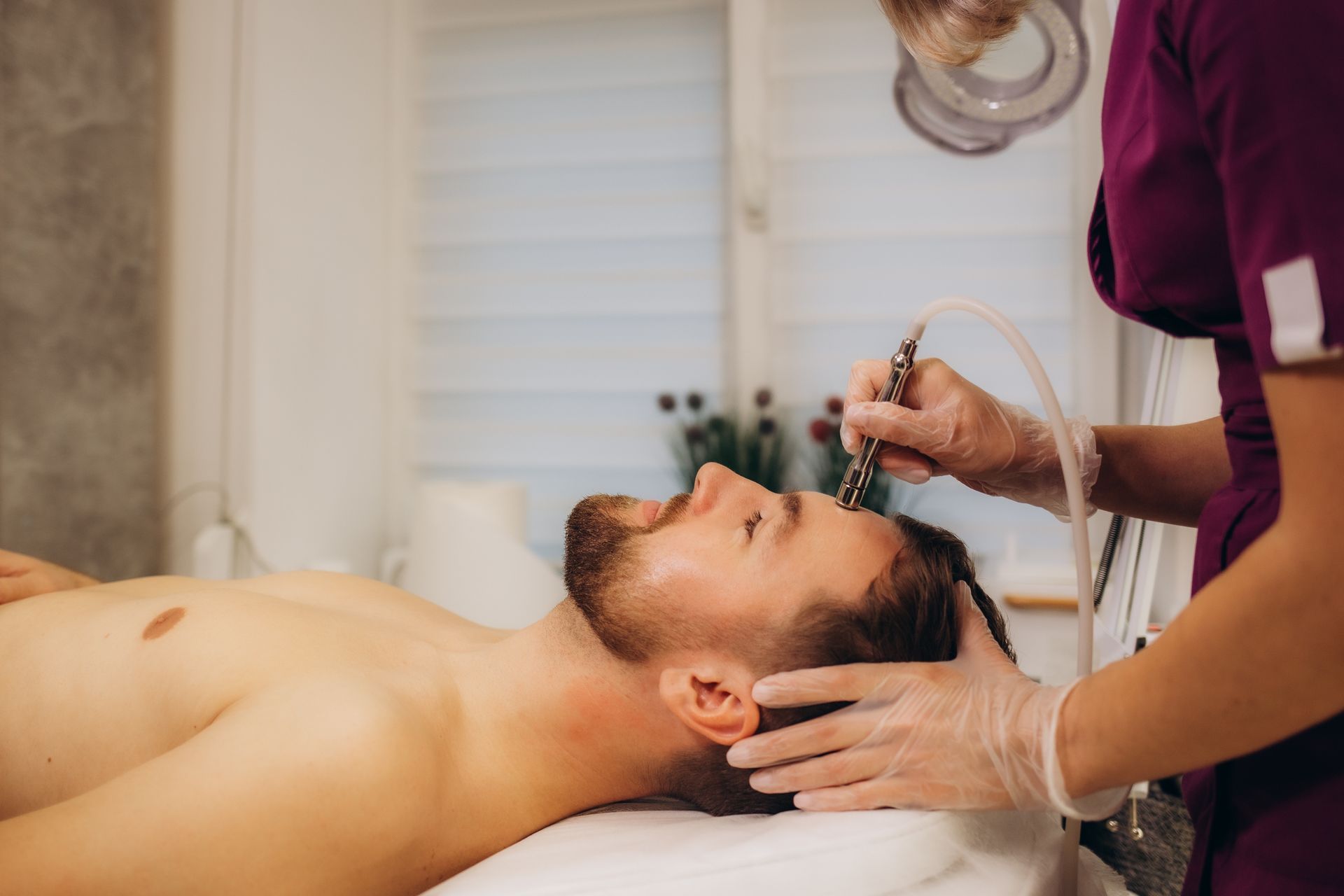 A man is getting a facial treatment at a beauty salon.