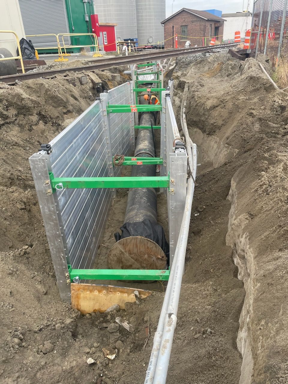 A large pipe is being installed in a trench.