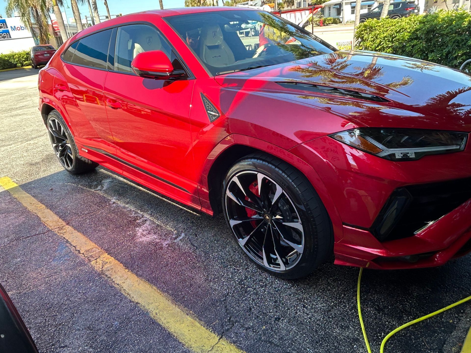 Red Lamborghini SUV parked on asphalt.