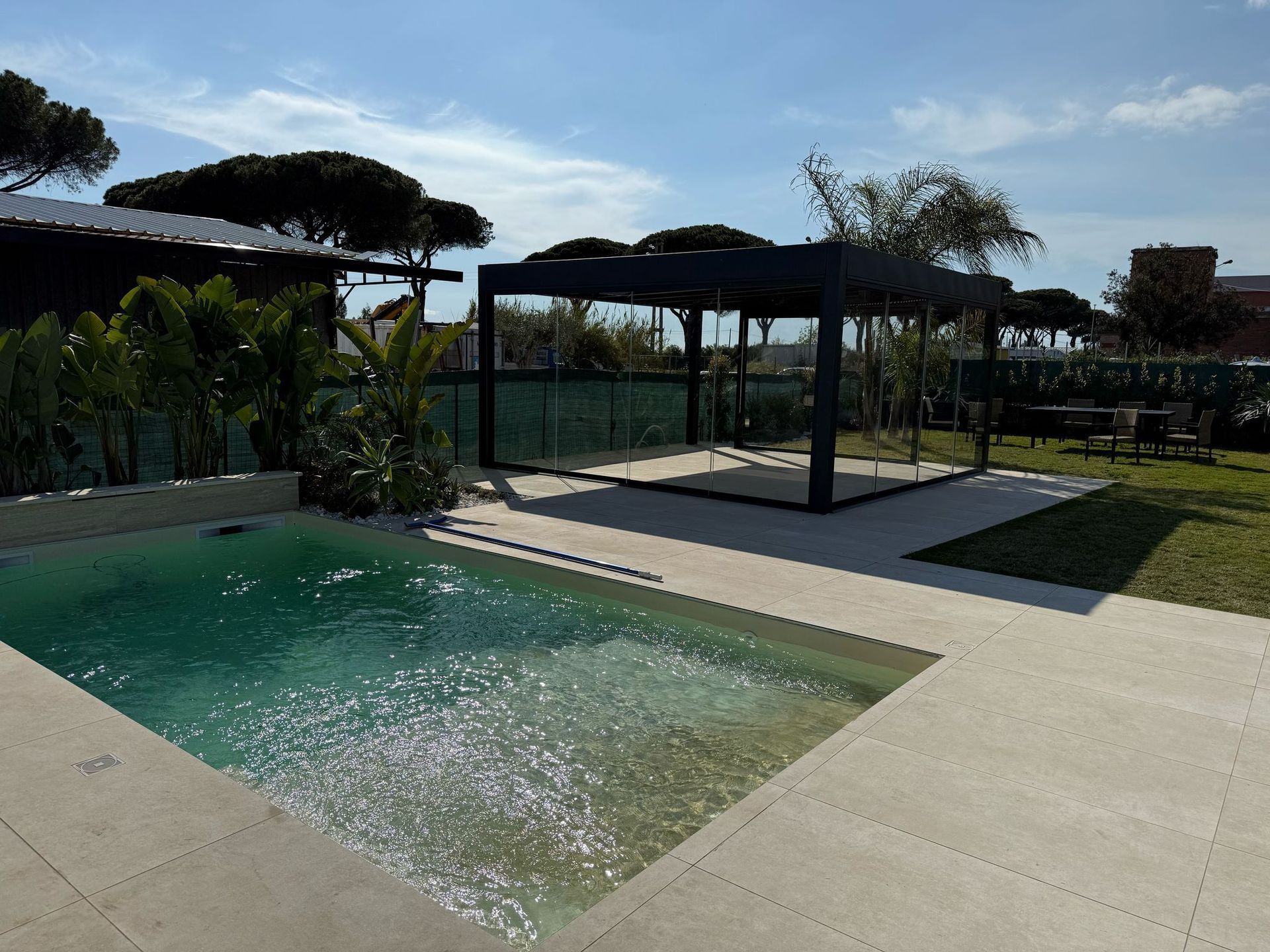 Patio sul retro con una piccola piscina, zona relax coperta e prato in pieno sole.