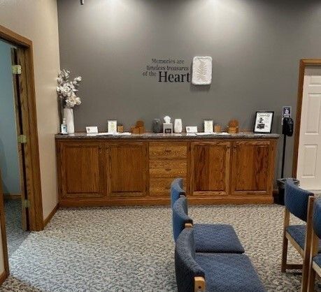 Waiting area with wood cabinetry, grey wall, and blue chairs.  Text on wall: 
