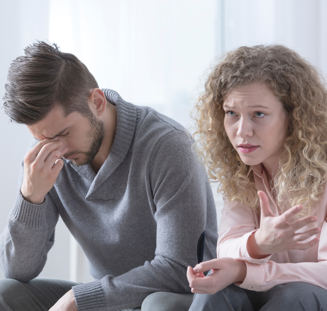 A man and a woman are sitting next to each other on the couch.