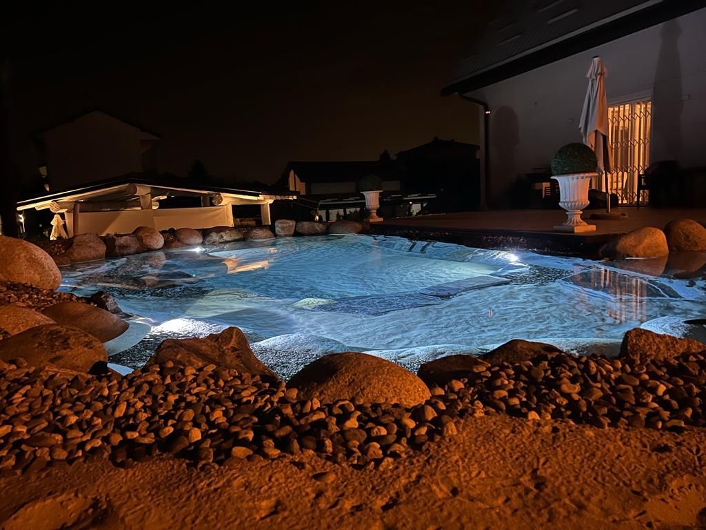 piscina naturale modello Caraibi con sabbia e rocce di Rocks Design