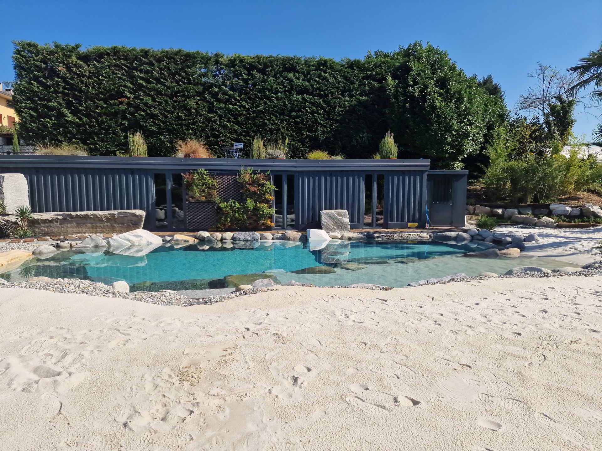 piscina naturale modello Caraibi con sabbia e rocce di Rocks Design
