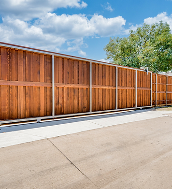 A wooden fence is sitting on the side of a road.