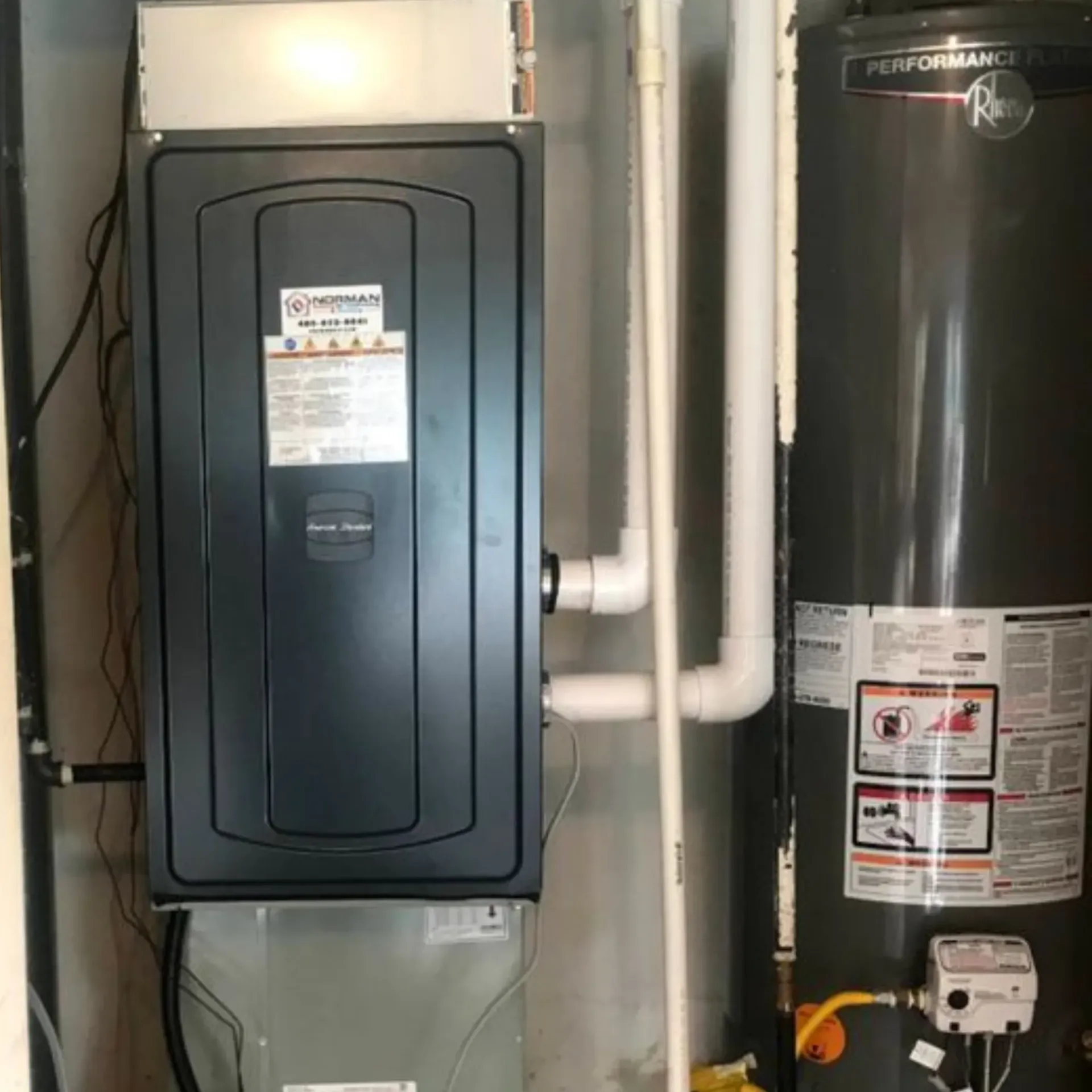 Finnegan’s Heating Air Conditioning - There is a water heater and an air conditioner in the room.