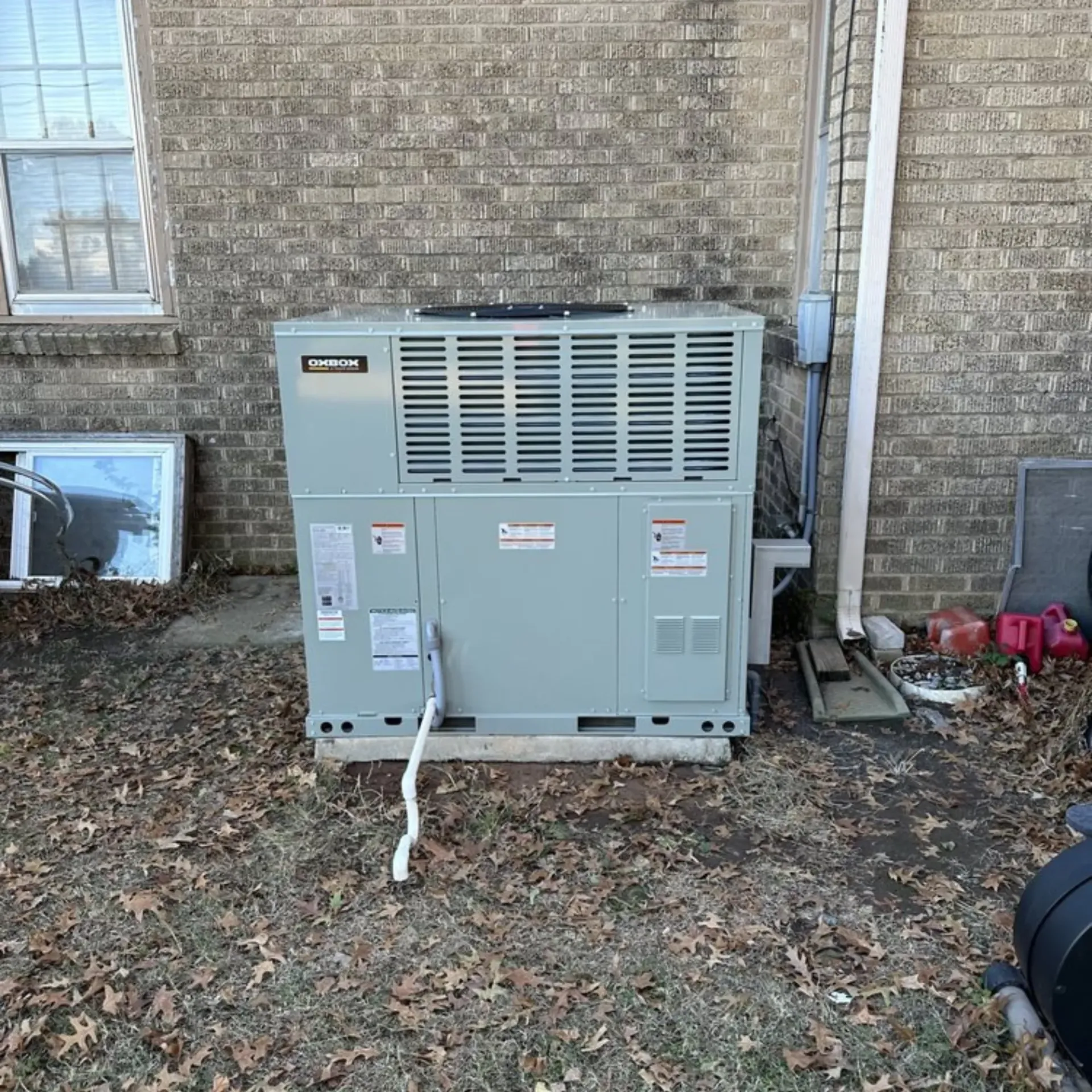 Finnegan’s Heating Air Conditioning - A large air conditioner is sitting outside of a brick building.