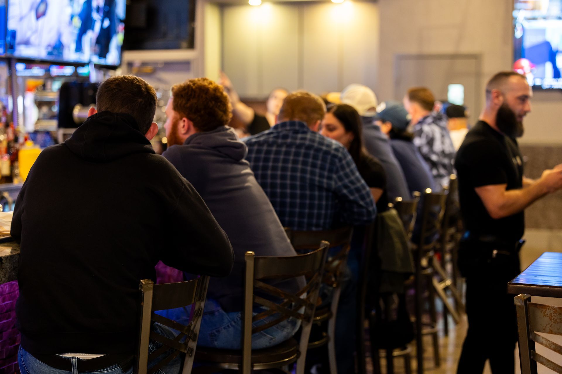 Friends raising beer glasses at a holiday party in a Middlebury CT brewpub