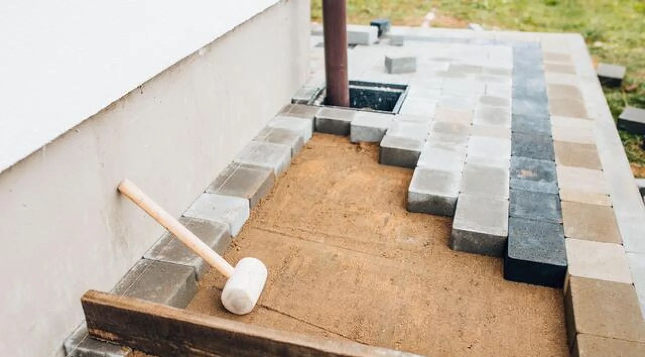 Construction site with roof tiles, a mallet, and a partially installed roof surface