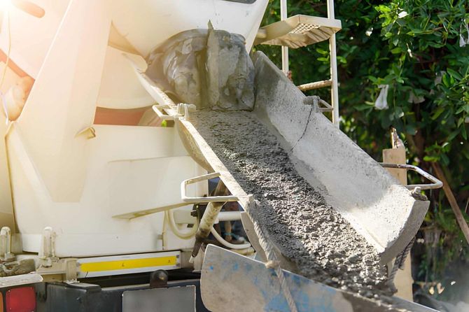 Concrete pouring from a truck chute into a construction site mixer