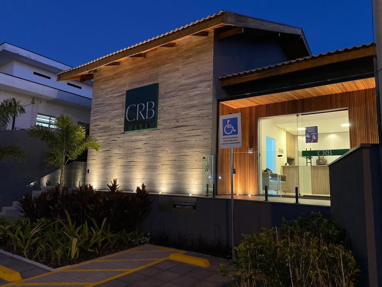 Fachada do prédio ao entardecer com a placa iluminada 