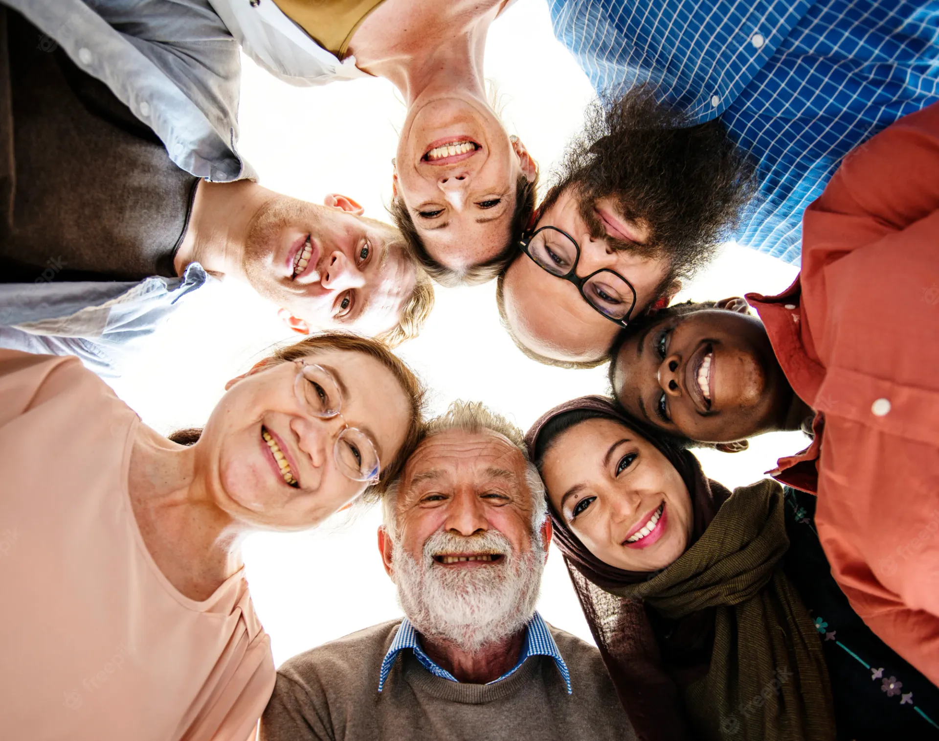 A group of people are standing in a circle and smiling at the camera.