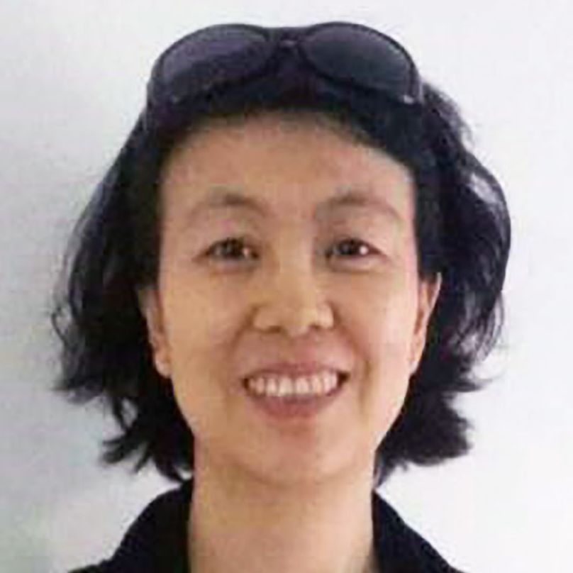 A woman wearing sunglasses is smiling for the camera.
