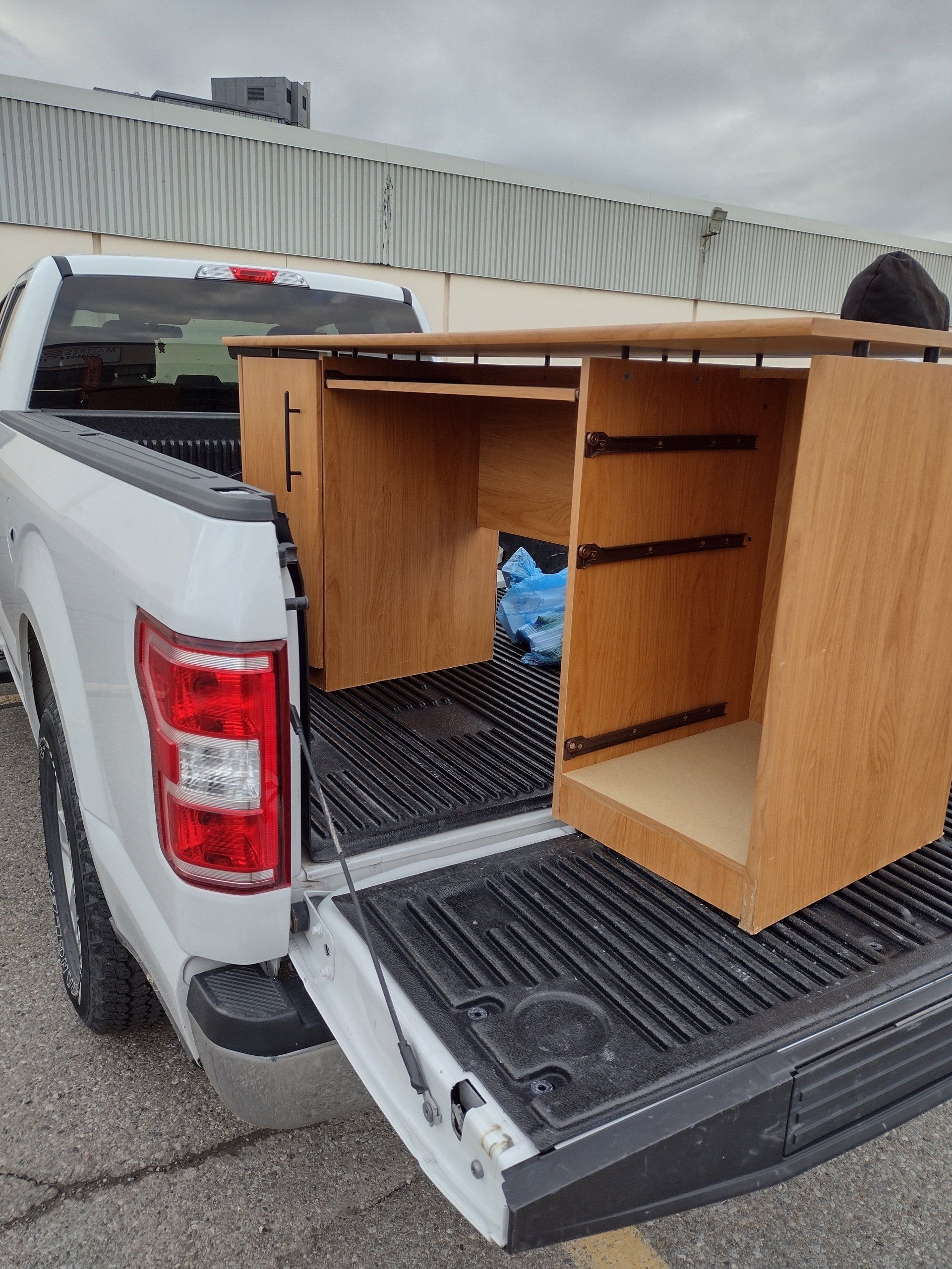 A white truck with a desk in the back of it.