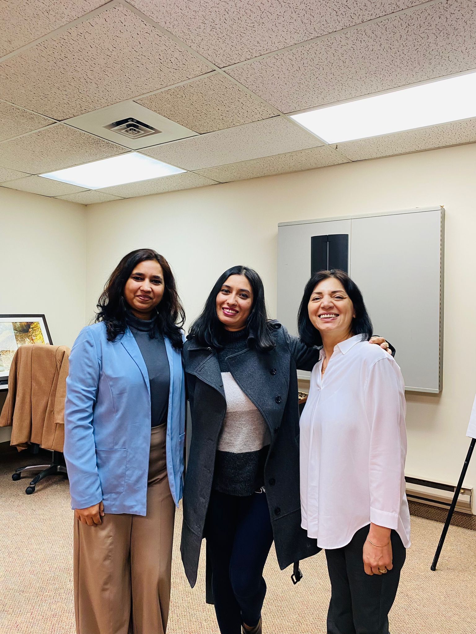Three women are posing for a picture in a room.