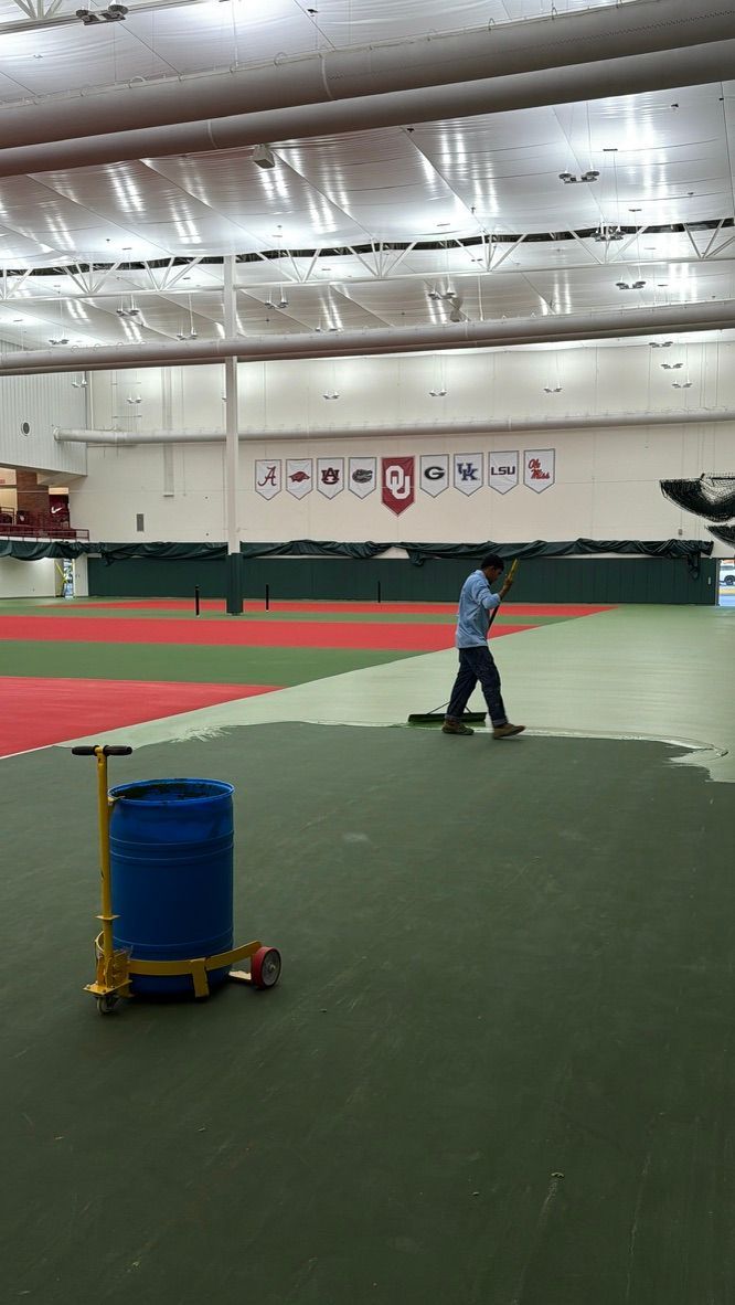 Three blue tennis courts in front of a large beige clubhouse with a red roof