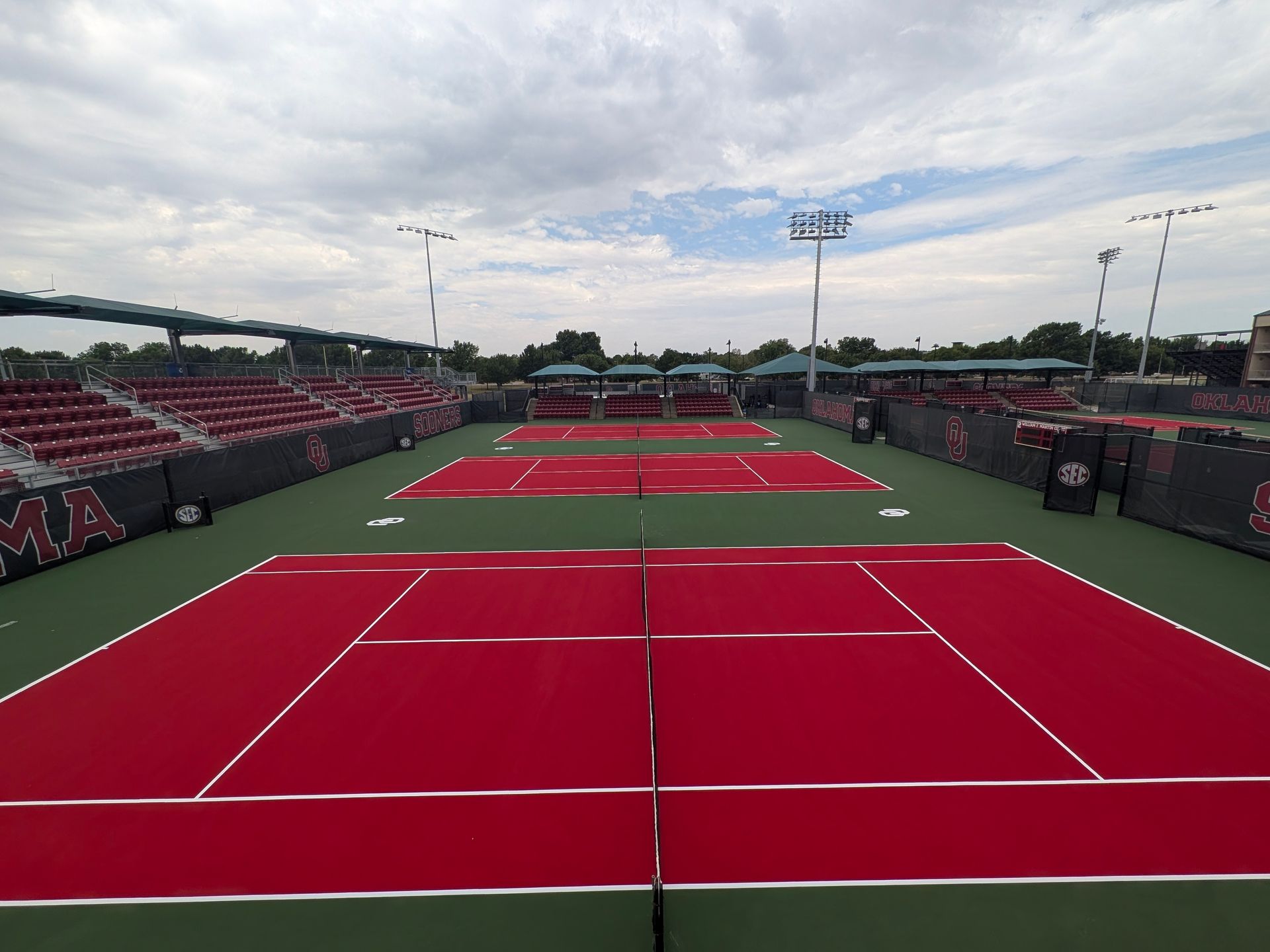 Outdoor pickleball courts with blue and green surfaces and nets, seen on a sunny day.