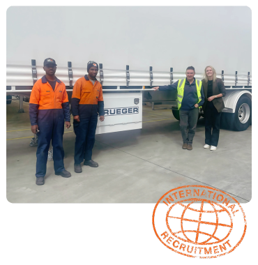 Four people stand in front of a client truck, including two workers in high-vis uniforms, a client and a recruitment manager, representing skilled trades recruitment.