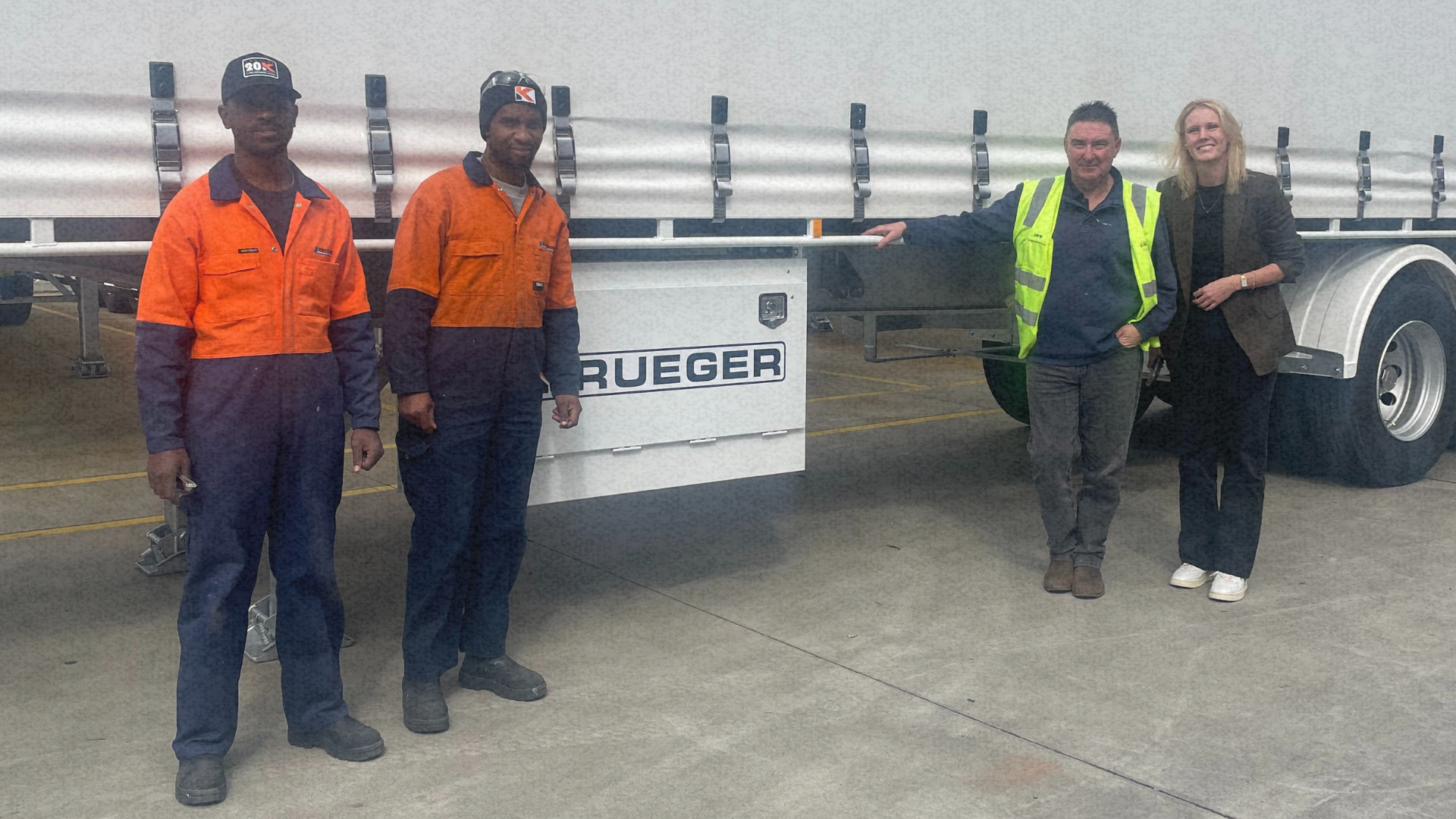 Four people stand in front of a client truck, including two workers in high-vis uniforms, a client and a recruitment manager, representing skilled trades recruitment.