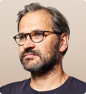 A man with glasses and a beard is wearing a black shirt