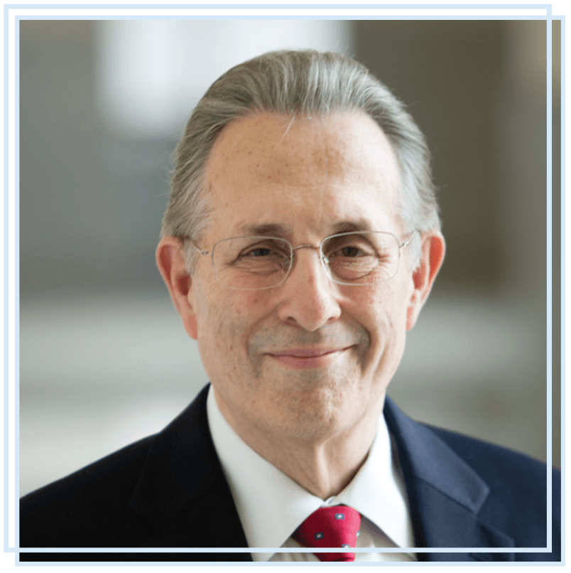 A man in a suit and tie is smiling for the camera