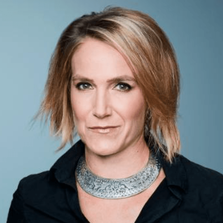 A woman wearing a black shirt and a silver necklace is smiling for the camera.