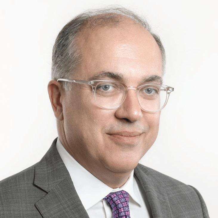 A man in a suit and tie is wearing glasses.