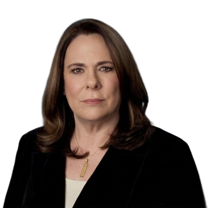 Portrait of a woman in a black blazer against a white background, looking directly at the camera.