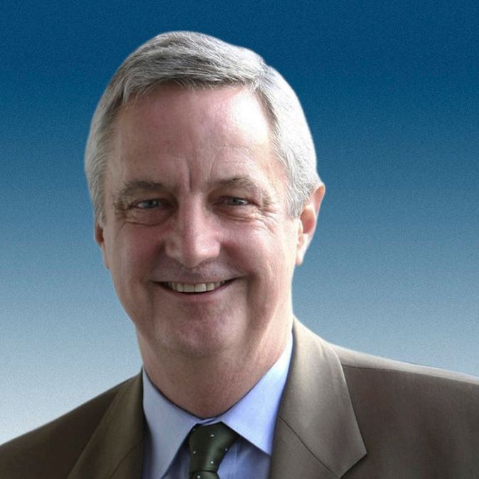 A man in a suit and tie is smiling for the camera.